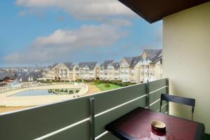 a balcony with a table and a view of a building at Soleil du Crouesty - garage et piscine partagée in Arzon