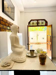 una statua di Buddha seduta su un tavolo di Royal Homes and Wellness Center a Kurunegala