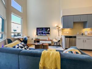 a living room with a blue couch and a kitchen at Creative 2 Levels Penthouse in Los Angeles