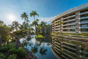 an exterior view of a building with palm trees at Hilton Grand Vacations Club Ocean Tower Waikoloa Village in Waikoloa