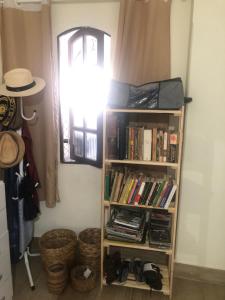 a book shelf in a room with books at Quarto privativo Sanilda in Vitória