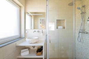 a bathroom with a glass shower and a sink at Monte do Cerro in Porto Covo