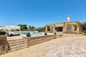 a house with a swimming pool and a patio at Perla Bianca by Perle di Puglia in Torre San Giovanni Ugento