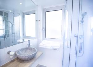 La salle de bains est pourvue d'un grand lavabo en pierre et d'une douche. dans l'établissement Tiercé Hotel, à Cagnes-sur-Mer