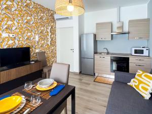 ein Wohnzimmer mit einem Esstisch und einer Küche in der Unterkunft SE048 - Marotta, nuovo bilocale fronte mare in Marotta