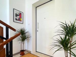 a white door in a hallway with two plants at SE048 - Marotta, nuovo bilocale fronte mare in Marotta