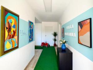 a room with paintings on the walls and a green floor at SE048 - Marotta, nuovo bilocale fronte mare in Marotta