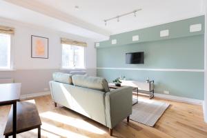 uma sala de estar com um sofá e uma televisão em The Tower Bridge Apartments em Londres