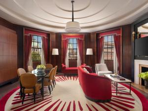 a living room with a table and red chairs at Raffles London at The OWO in London