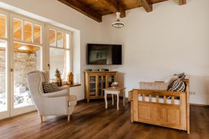 a living room with a tv and a chair and a table at Domeček v Chaloupkách in Zdice