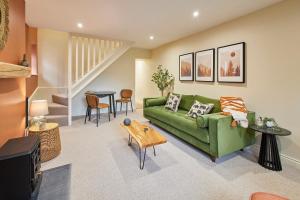 a living room with a green couch and a table at Host & Stay - Cinnamon Cottage in Barnard Castle
