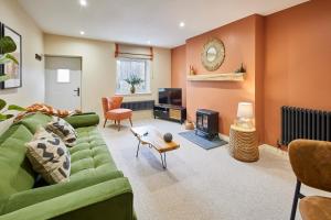 ein Wohnzimmer mit einer grünen Couch und einem Kamin in der Unterkunft Host & Stay - Cinnamon Cottage in Barnard Castle + 13 Fotos