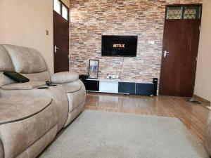 ein Wohnzimmer mit Sofa und Ziegelwand in der Unterkunft Fair deal Apartment in Mombasa