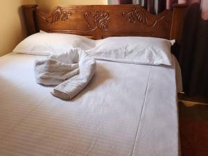 un asciugamano bianco appoggiato sopra un letto di Fair deal Apartment a Mombasa