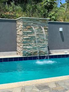 een fontein in een zwembad met bij Sitio Canto Caipira in Vila Velha