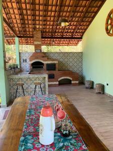 een woonkamer met een houten tafel en een keuken bij Sitio Canto Caipira in Vila Velha