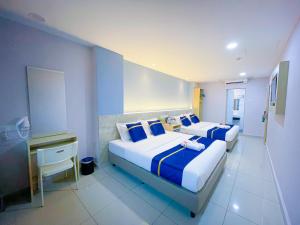 クアラルンプールにあるStarQ Hotel Kuala Lumpurのベッドルーム1室(青と白のシーツが備わるベッド2台付)
