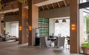 a lobby with a table and chairs in a building at Radisson Safari Hotel Hoedspruit in Hoedspruit