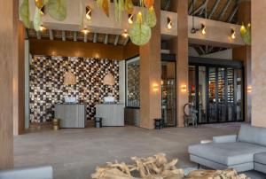 a lobby of a hotel with a table and a couch at Radisson Safari Hotel Hoedspruit in Hoedspruit