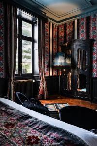 - une chambre avec une table, une lampe et une fenêtre dans l'établissement Château de Maubreuil, à Carquefou