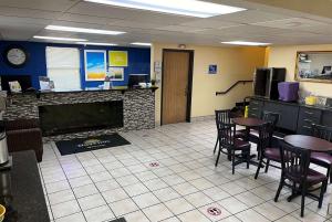 a waiting room with tables and chairs and a fireplace at Days Inn by Wyndham Park City Kansas in Park City