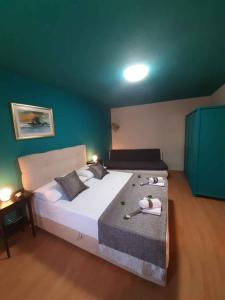 ein Schlafzimmer mit einem großen weißen Bett und einer blauen Wand in der Unterkunft Apartments in Pucisca/Insel Brac 6052 in Pučišća