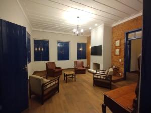 a living room with chairs and a couch and a table at Fazenda São Miguel in Monte Alegre do Sul