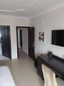 a living room with a flat screen tv on the wall at St Theresers apartment Lodge 2 in Lekki