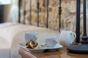 una mesa con dos tazas y un plato de comida en Case Passamonte Agriturismo Resort & Rooms en Chiaramonte Gulfi