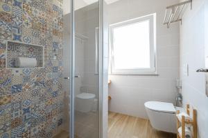 a bathroom with a toilet and a glass shower at Monte do Cerro in Porto Covo