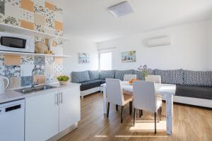 een keuken en een woonkamer met een tafel en stoelen bij Monte do Cerro in Porto Covo