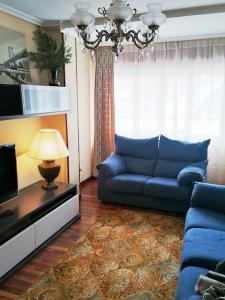 un soggiorno con divano blu e TV di Ampuero, Cantabria, RÍO ASÓN. Hasta 6 personas ad Ampuero