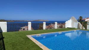 a swimming pool with the ocean in the background at Vistafaro in Es Mercadal