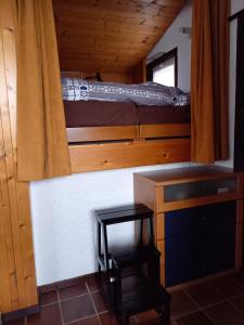 a room with a bunk bed and a desk and a chair at Le Perchoir in Gryon