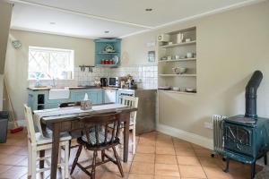 a kitchen with a wooden table and a stove at The Rose Cottage in Thomastown