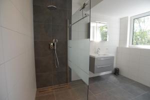 a bathroom with a shower and a sink at Razende Bol in De Koog