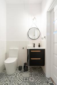 La salle de bains est pourvue de toilettes, d'un lavabo et d'un miroir. dans l'établissement RentPlanet - Apartament Cybulskiego, à Wrocław