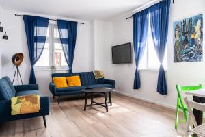 - un salon avec deux canapés bleus et une télévision dans l'établissement RentPlanet - Apartament Cybulskiego, à Wrocław