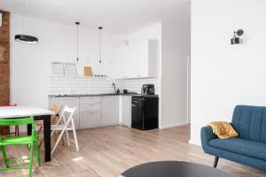 Il dispose d'une cuisine et d'un salon avec un canapé et une table. dans l'établissement RentPlanet - Apartament Cybulskiego, à Wrocław