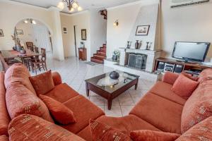 a living room with a couch and a tv at Villa Agni Sea View in Agní