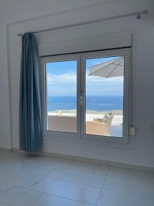 Zimmer mit einem Fenster und Strandblick in der Unterkunft Wonderful Santorini Villa - 2 Bedroom - Dream Villa Tria - Stunning Sea Views and Private Pool - Vourvoulos in Vourvoúlos