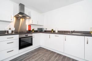 a kitchen with white cabinets and a stove at Luxury Apartment - Twin Beds - Selly Oak - Off-street Parking - Free Netflix & Wifi - Top Rated 9CC in Birmingham
