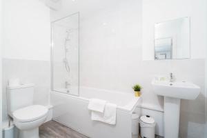 Baño blanco con aseo y lavamanos en Luxury Apartment - Twin Beds - Selly Oak - Off-street Parking - Free Netflix & Wifi - Top Rated 9CC, en Birmingham