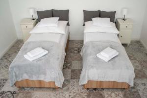 two beds in a room with blankets and pillows at Marelle Porta in Veresegyház