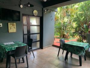 jadalnia z dwoma stołami i dużym oknem w obiekcie Ambar House Apart w mieście Puerto Iguazú
