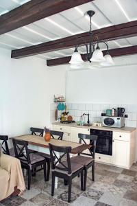 uma cozinha com mesa e cadeiras num quarto em Marelle Porta em Veresegyház