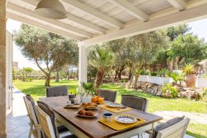 a wooden table and chairs on a patio at Villa Le Pigne in Favignana