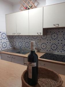 Una botella de vino sentada en una mesa en una cocina en Casa Alkabir Campello, en El Campello