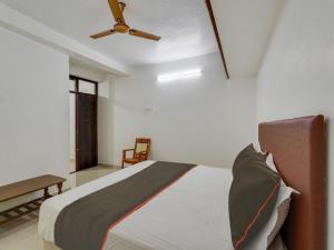 a bedroom with a bed with a ceiling fan at Collection O Anu Villas in Chennai