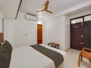 a bedroom with a bed and a ceiling fan at Collection O Anu Villas in Chennai